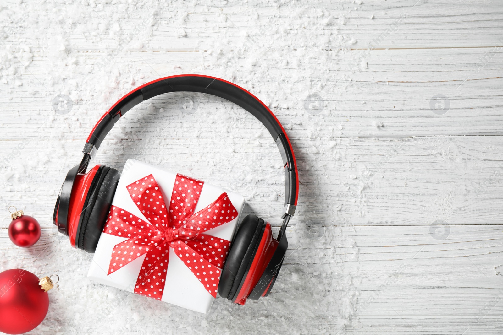 Photo of Flat lay composition with headphones on white wooden background, space for text. Christmas music concept