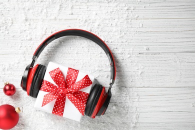 Photo of Flat lay composition with headphones on white wooden background, space for text. Christmas music concept