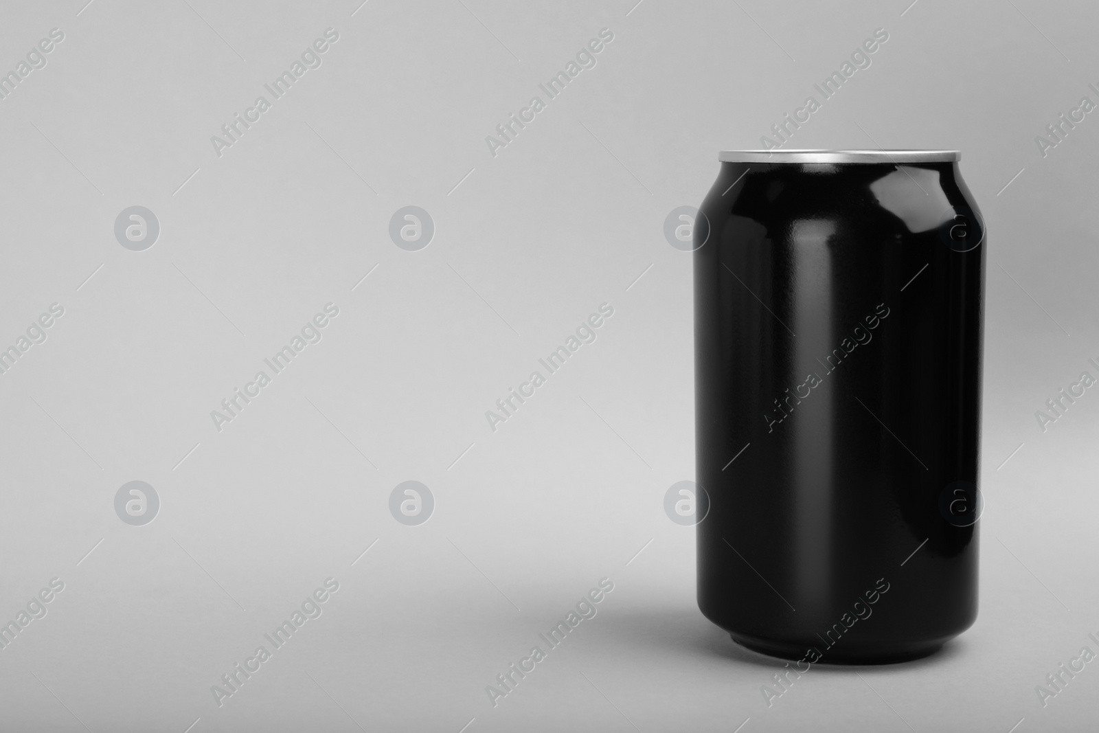 Photo of Black can of energy drink on light grey background. Space for text