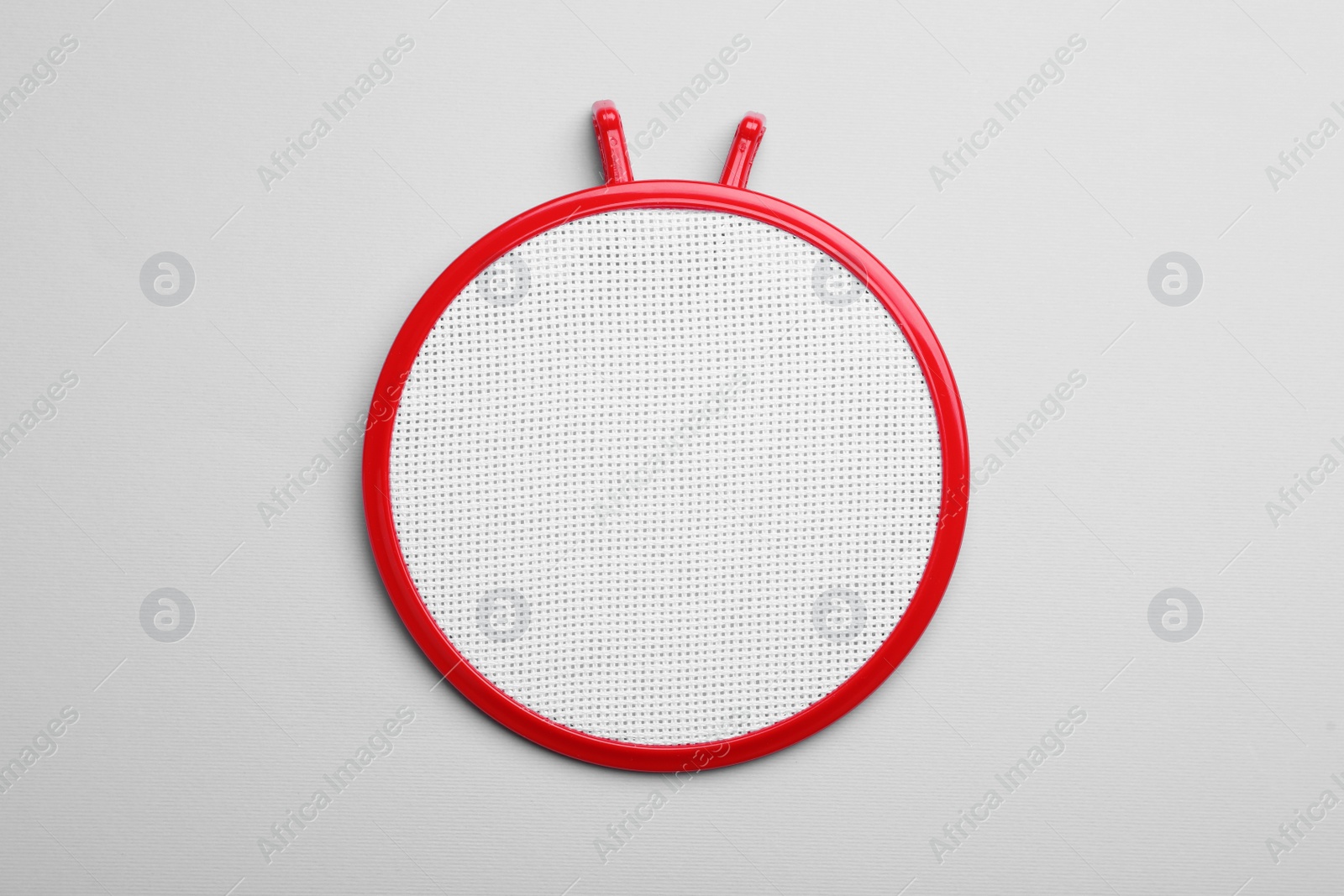 Photo of Embroidery hoop with fabric on light grey background, top view