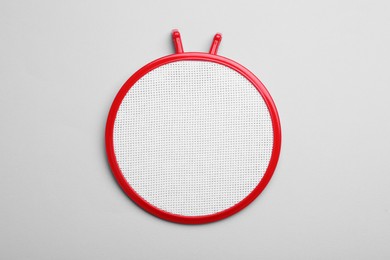 Photo of Embroidery hoop with fabric on light grey background, top view