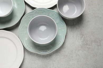 Beautiful ceramic dishware on light grey table, flat lay. Space for text