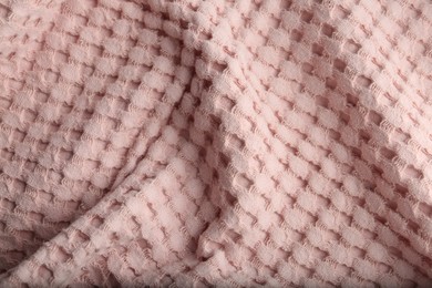 Photo of Texture of soft light pink fabric as background, closeup