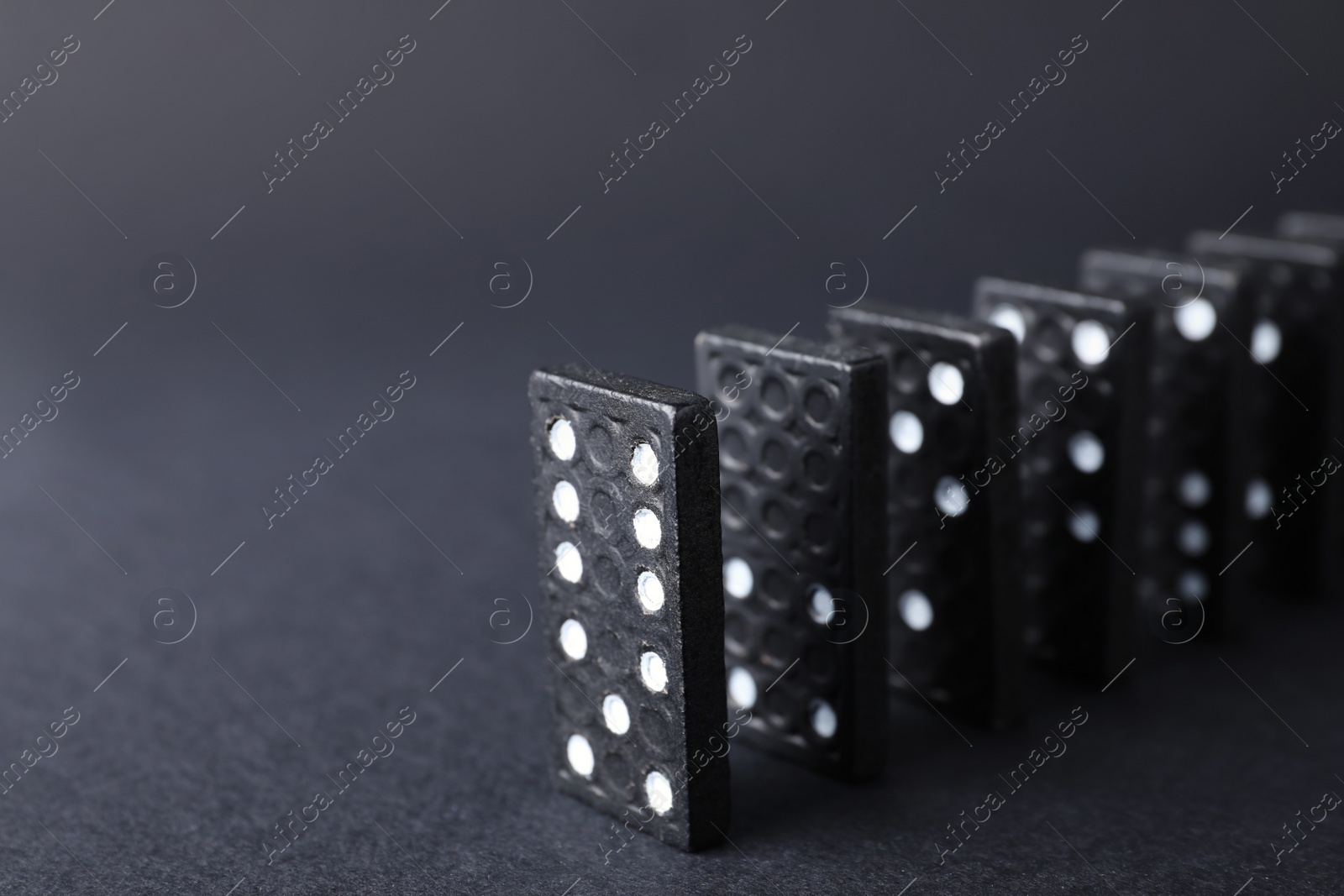 Photo of Domino tiles on black background, closeup. Space for text