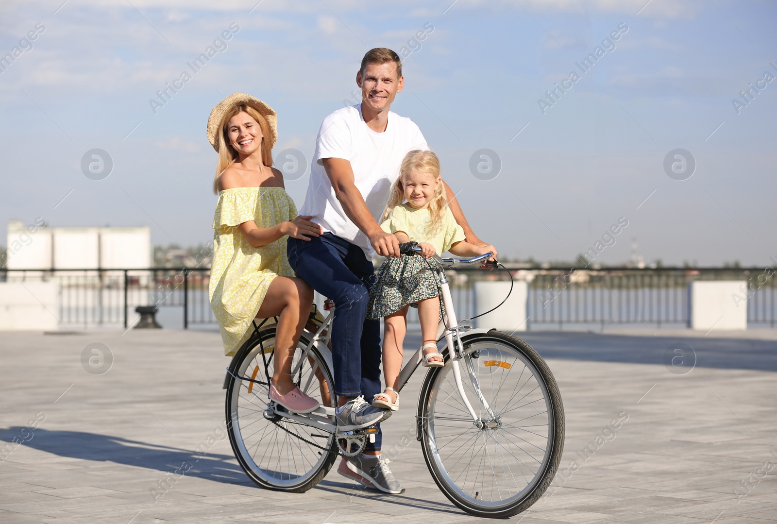 Photo of Happy family riding bicycle outdoors on sunny day