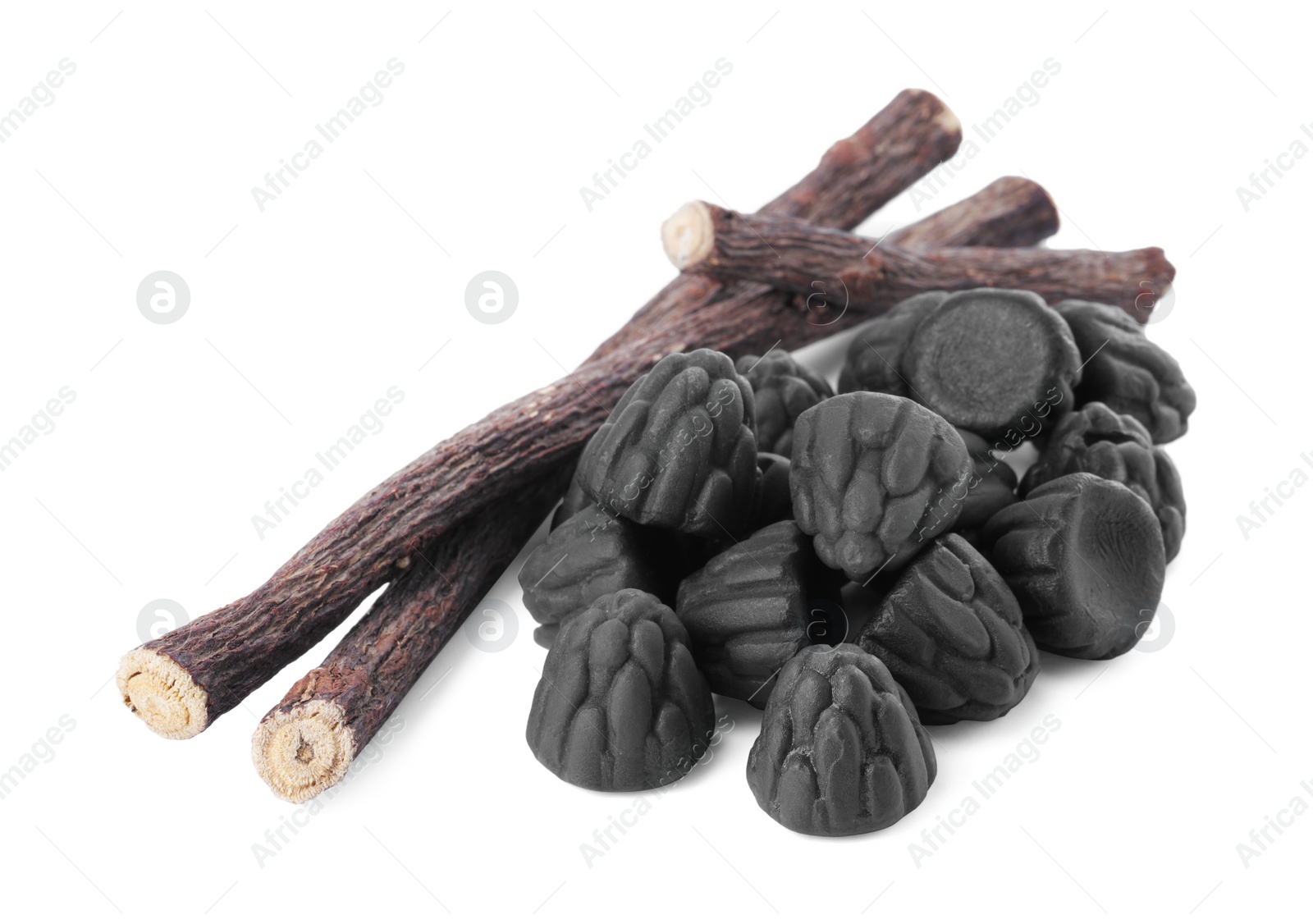 Photo of Many tasty candies and dried sticks of liquorice root isolated on white