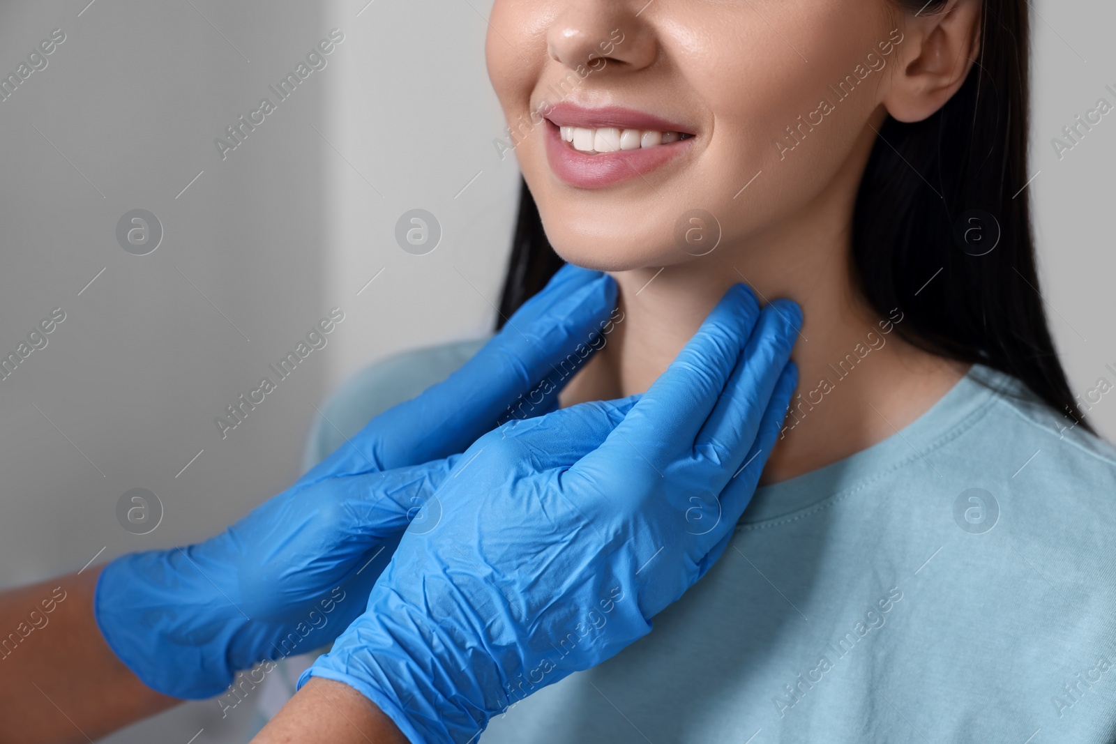 Photo of Endocrinologist examining thyroid gland of patient indoors, closeup