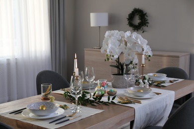 Beautiful Easter table setting with orchid flowers indoors