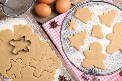 Photo of Making Christmas cookies. Flat lay composition with ingredients and raw dough on wooden table