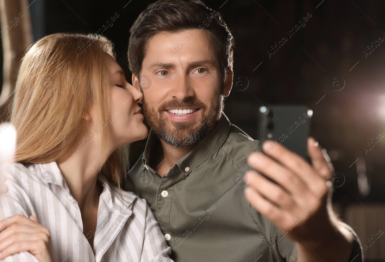 Photo of Romantic date. Happy couple taking selfie indoors