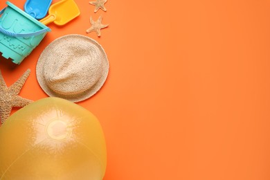 Photo of Beach ball, hat, starfishes and sand toys on orange background, flat lay. Space for text