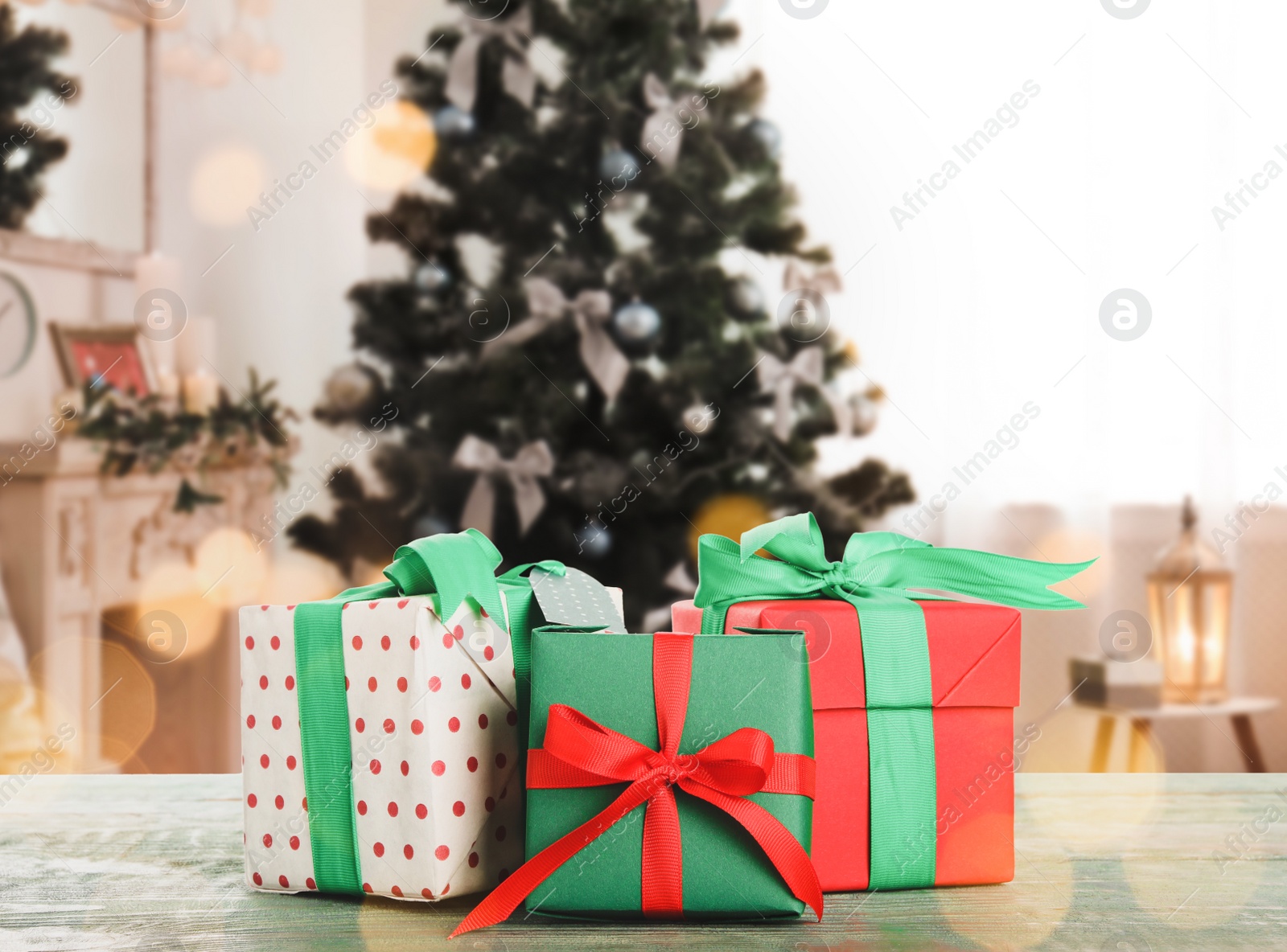 Image of Christmas gift boxes on wooden table in room, bokeh effect