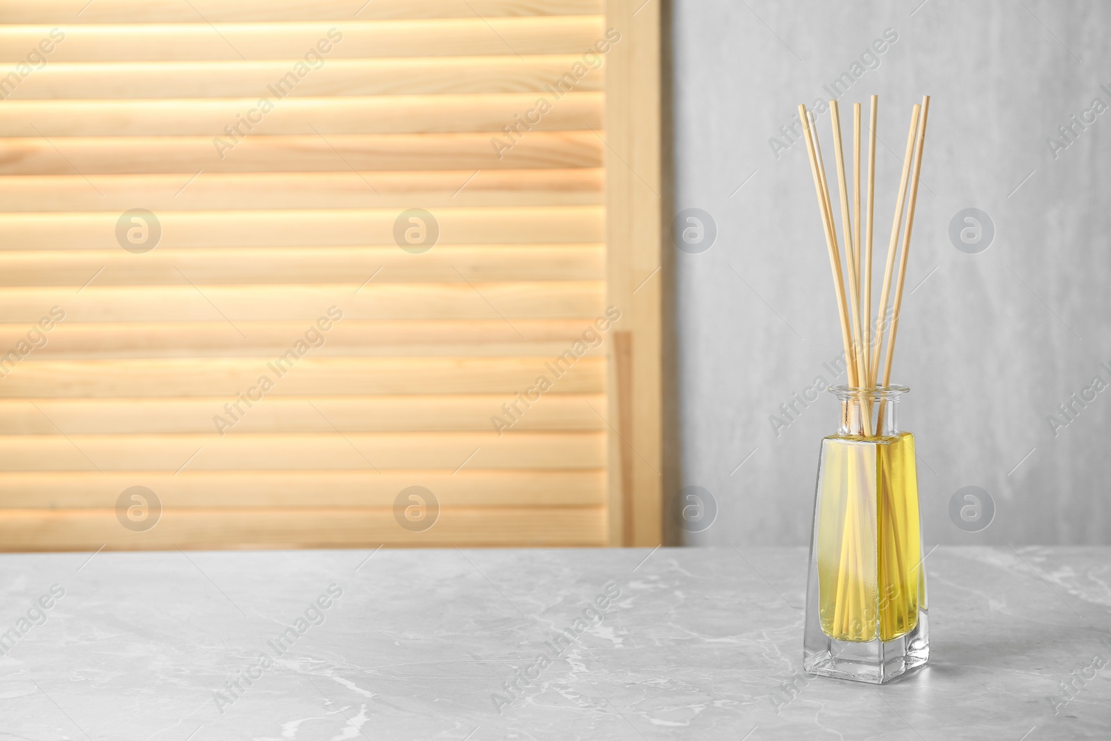 Photo of Aromatic reed freshener on grey table, space for text