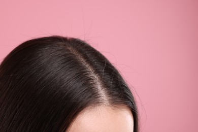 Photo of Woman with healthy dark hair on pink background, closeup. Space for text