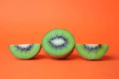 Photo of Cut fresh ripe kiwis on orange background