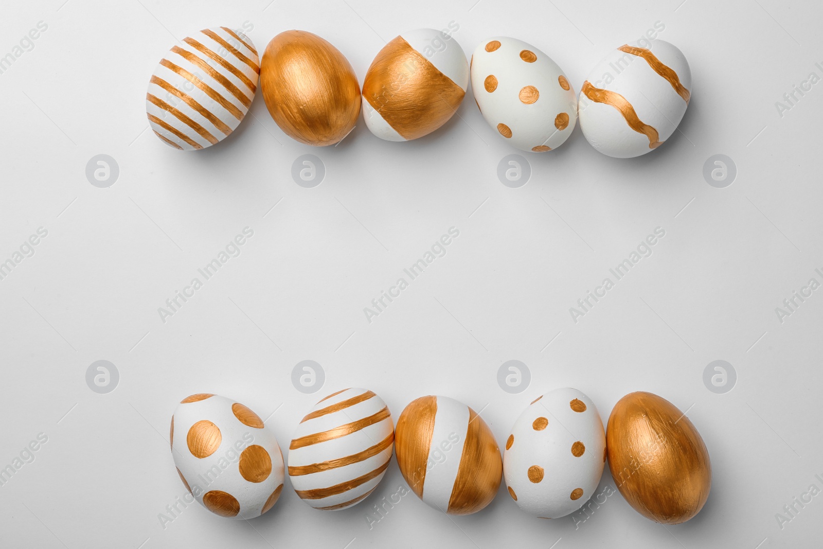 Photo of Set of traditional Easter eggs decorated with golden paint on white background, top view. Space for text