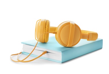 Modern headphones with hardcover book on white background