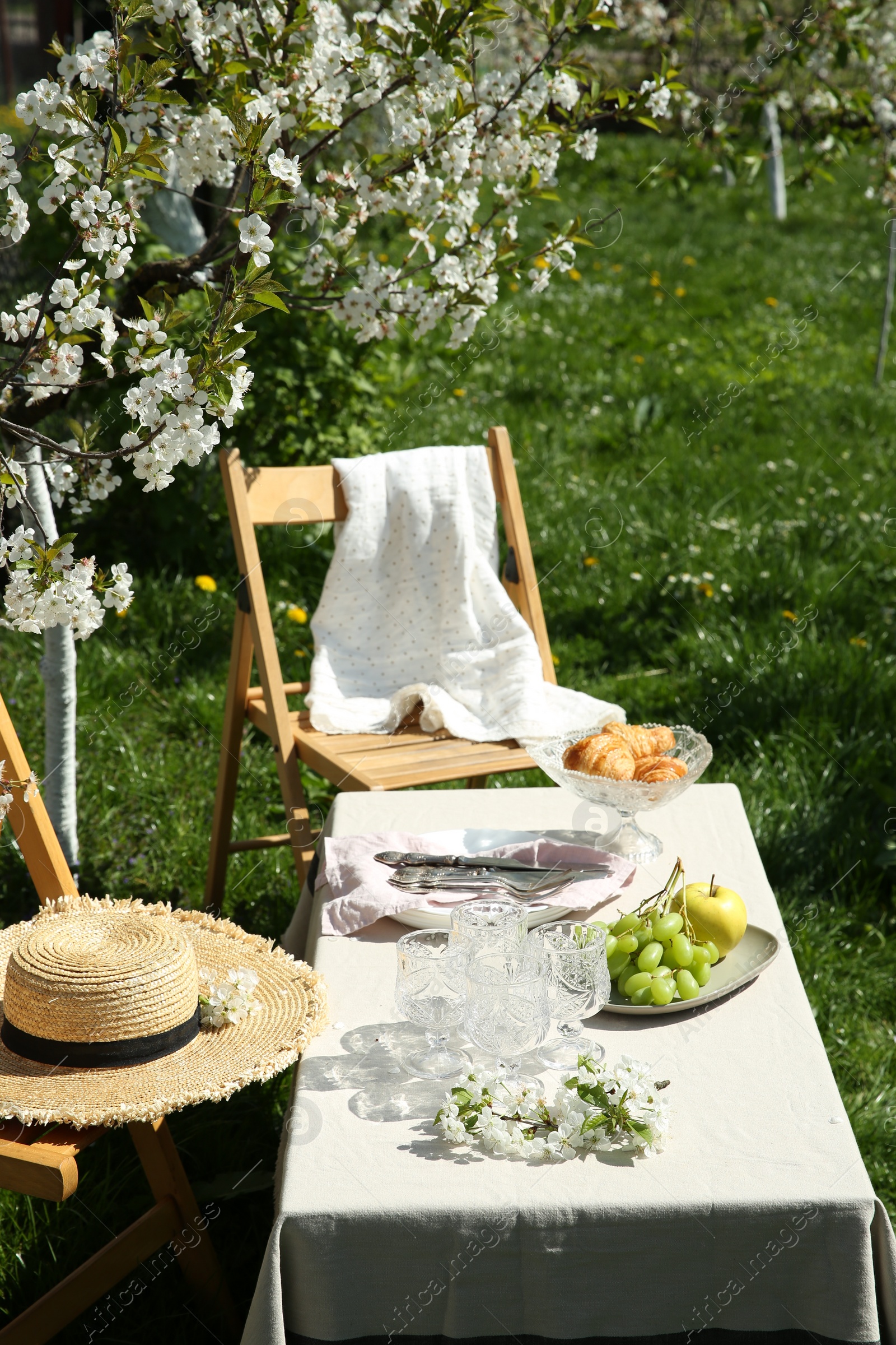 Photo of Stylish table setting with beautiful spring flowers in garden on sunny day