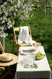 Photo of Stylish table setting with beautiful spring flowers in garden on sunny day