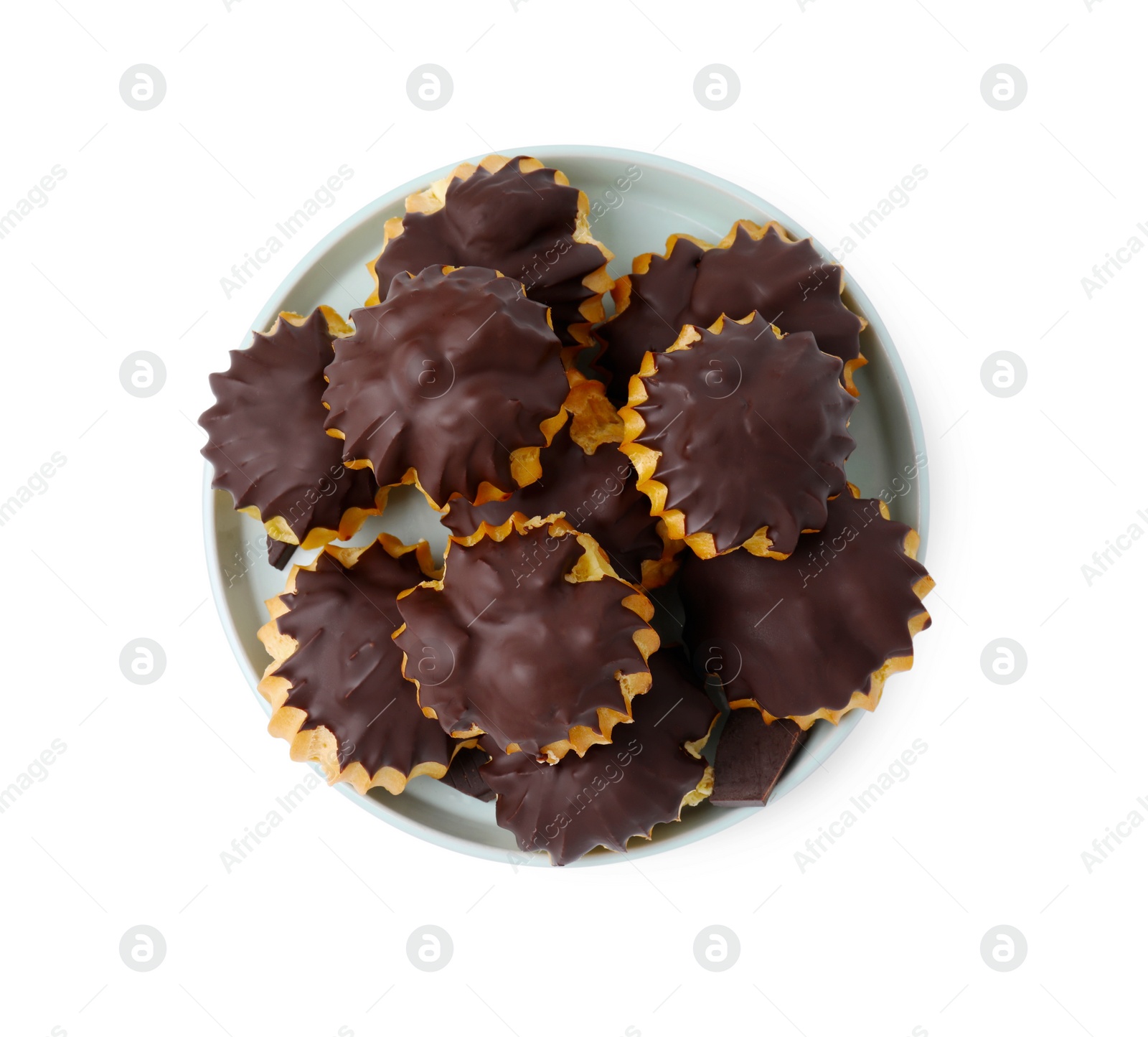 Photo of Delicious profiteroles with chocolate spread isolated on white, top view