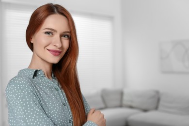 Portrait of beautiful young woman at home, space for text