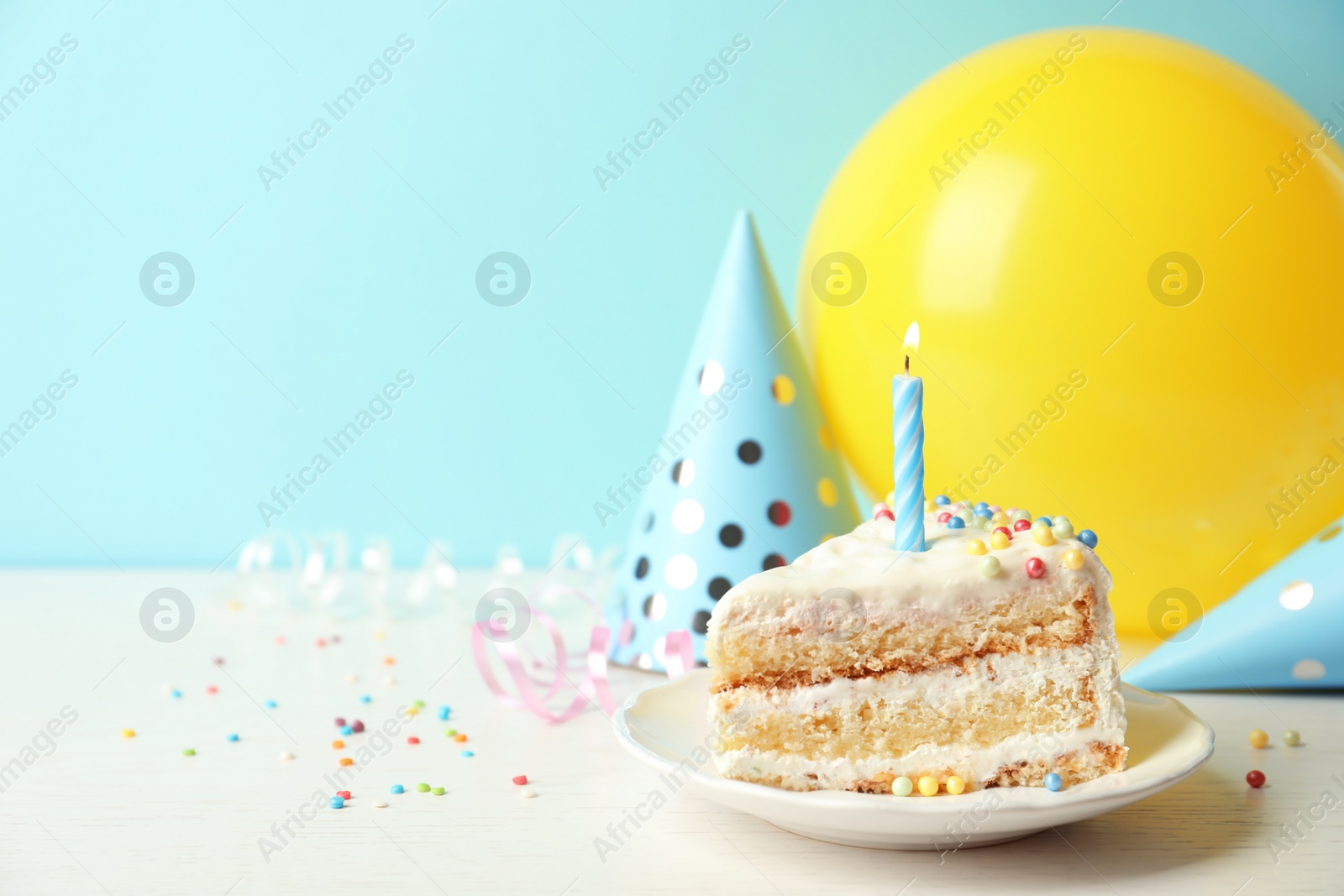 Photo of Slice of delicious birthday cake with candle on table