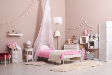 Photo of Cute child's room interior with toys and modern furniture