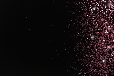 Photo of Rose gold glitter on black background, top view with space for text