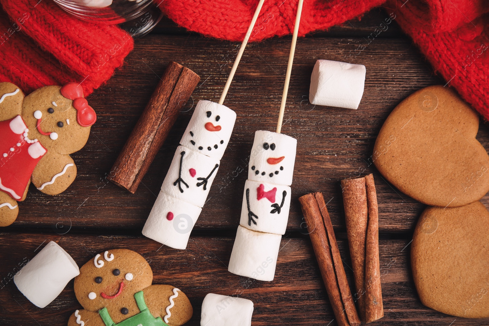 Photo of Flat lay composition with funny snowmen made of marshmallows on wooden table