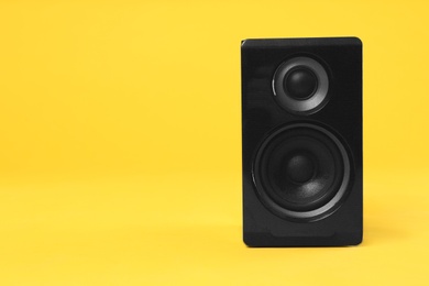 Modern powerful audio speaker on yellow background, space for text