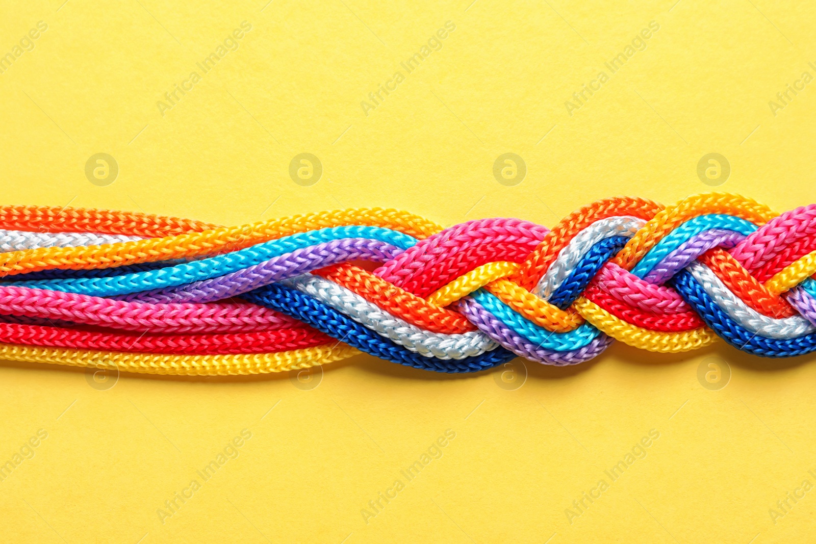 Photo of Braided ropes on color background, top view. Unity concept