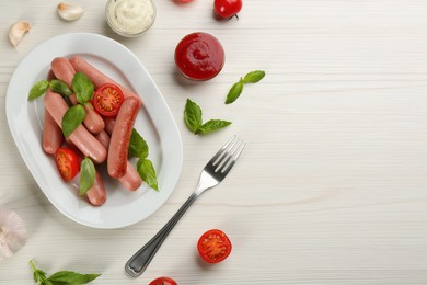Photo of Delicious vegetarian sausages with basil, vegetables and sauces on white wooden table, flat lay. Space for text