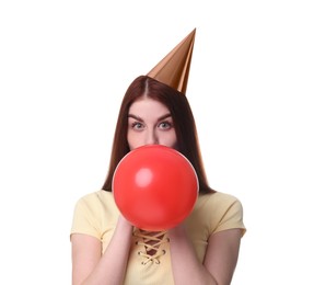 Photo of Young woman in party hat blowing balloon on white background