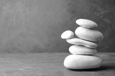 Photo of Stack of zen stones on table against grey background. Space for text