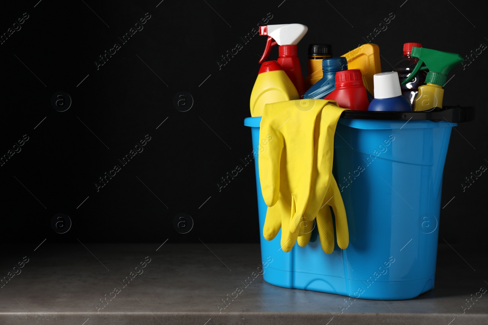 Photo of Light blue bucket with car cleaning products on grey table. Space for text