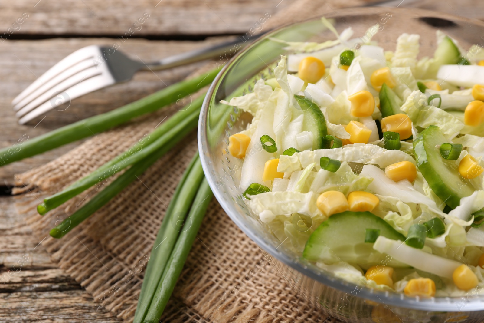 Photo of Tasty salad with Chinese cabbage on wooden table, closeup