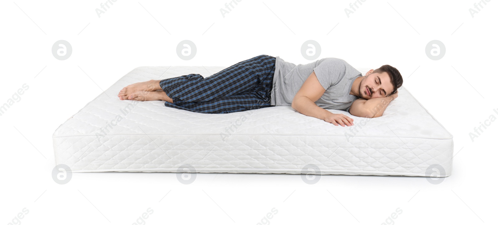 Photo of Young man lying on mattress against white background