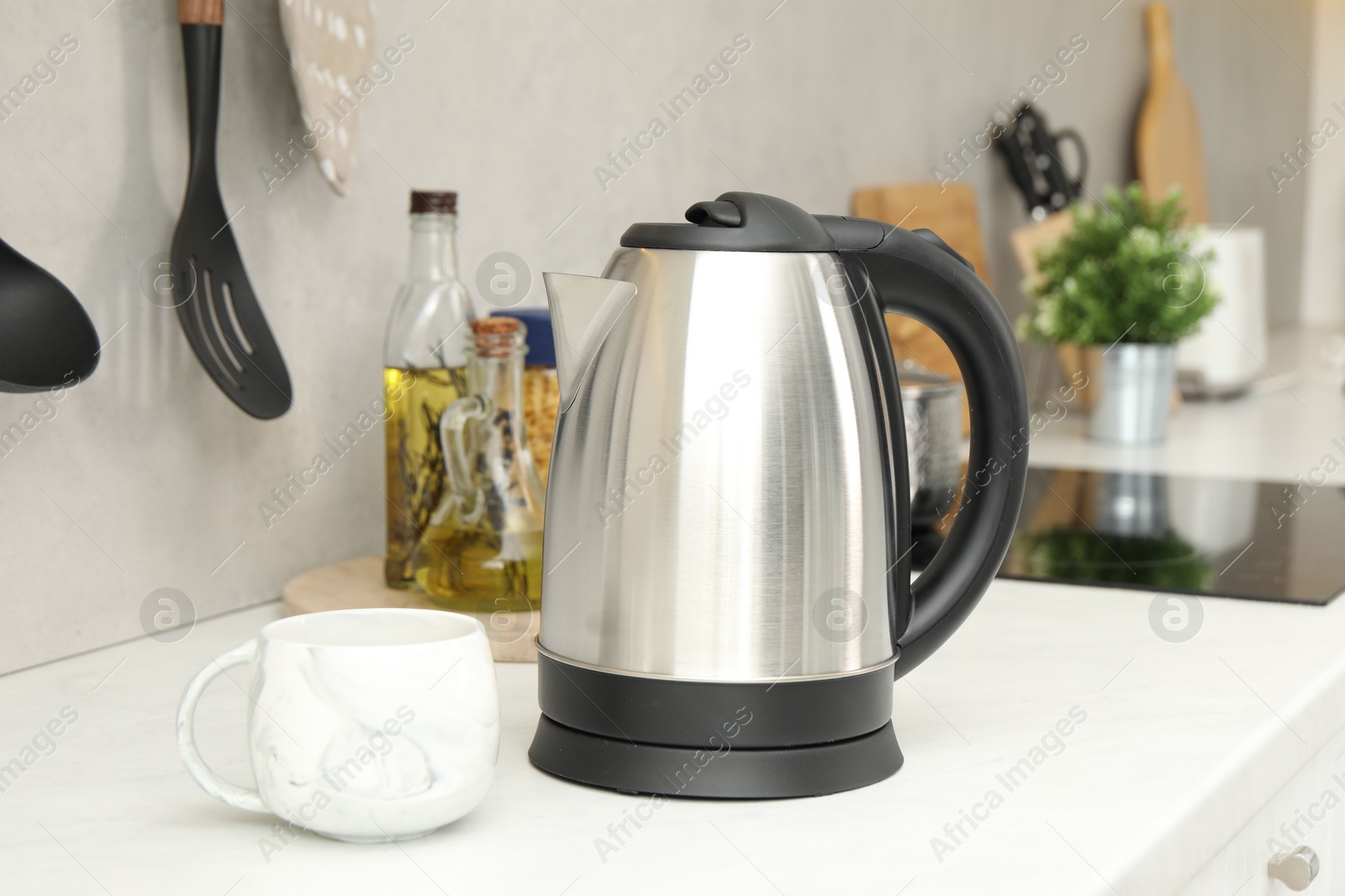 Photo of Electric kettle and cup on counter in kitchen