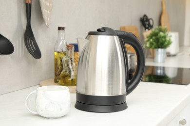 Electric kettle and cup on counter in kitchen