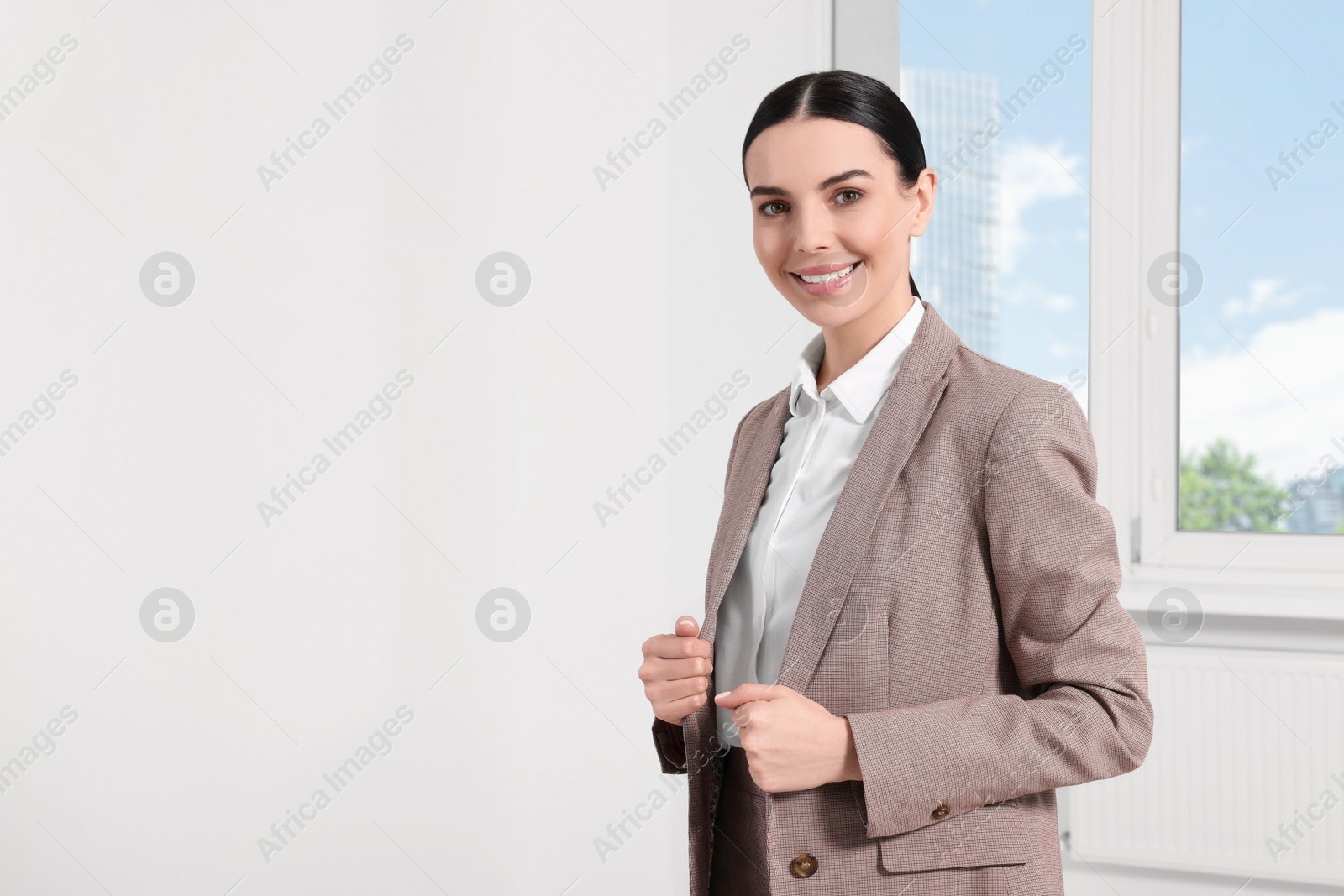 Photo of Beautiful real estate agent in nice suit indoors, space for text