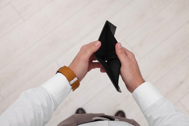 Photo of Man with empty wallet indoors, top view