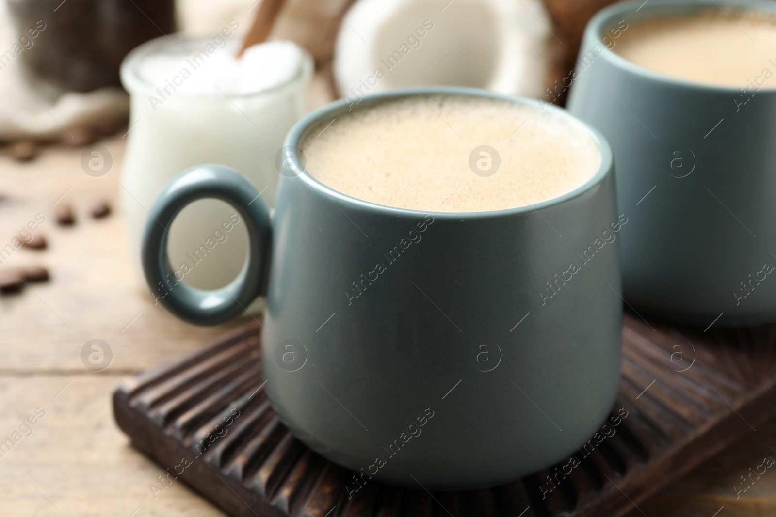 Photo of Delicious coffee with organic coconut oil on wooden table