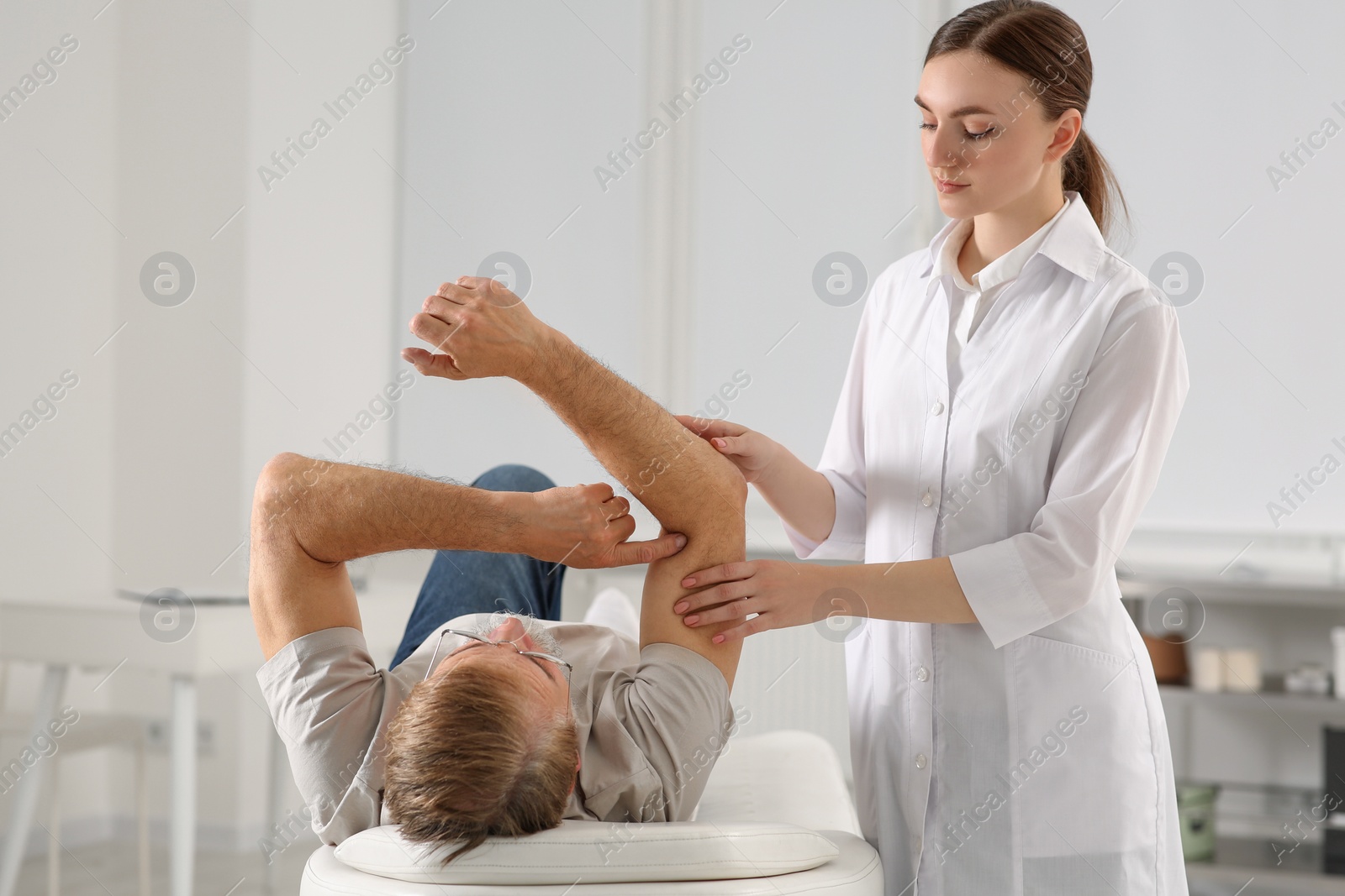 Photo of Professional orthopedist examining patient's arm in clinic