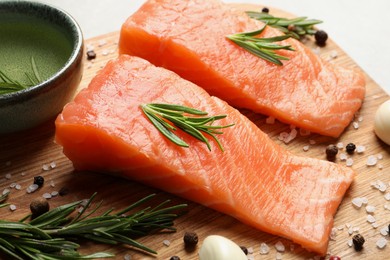 Photo of Fresh raw salmon and ingredients for marinade on wooden board, closeup