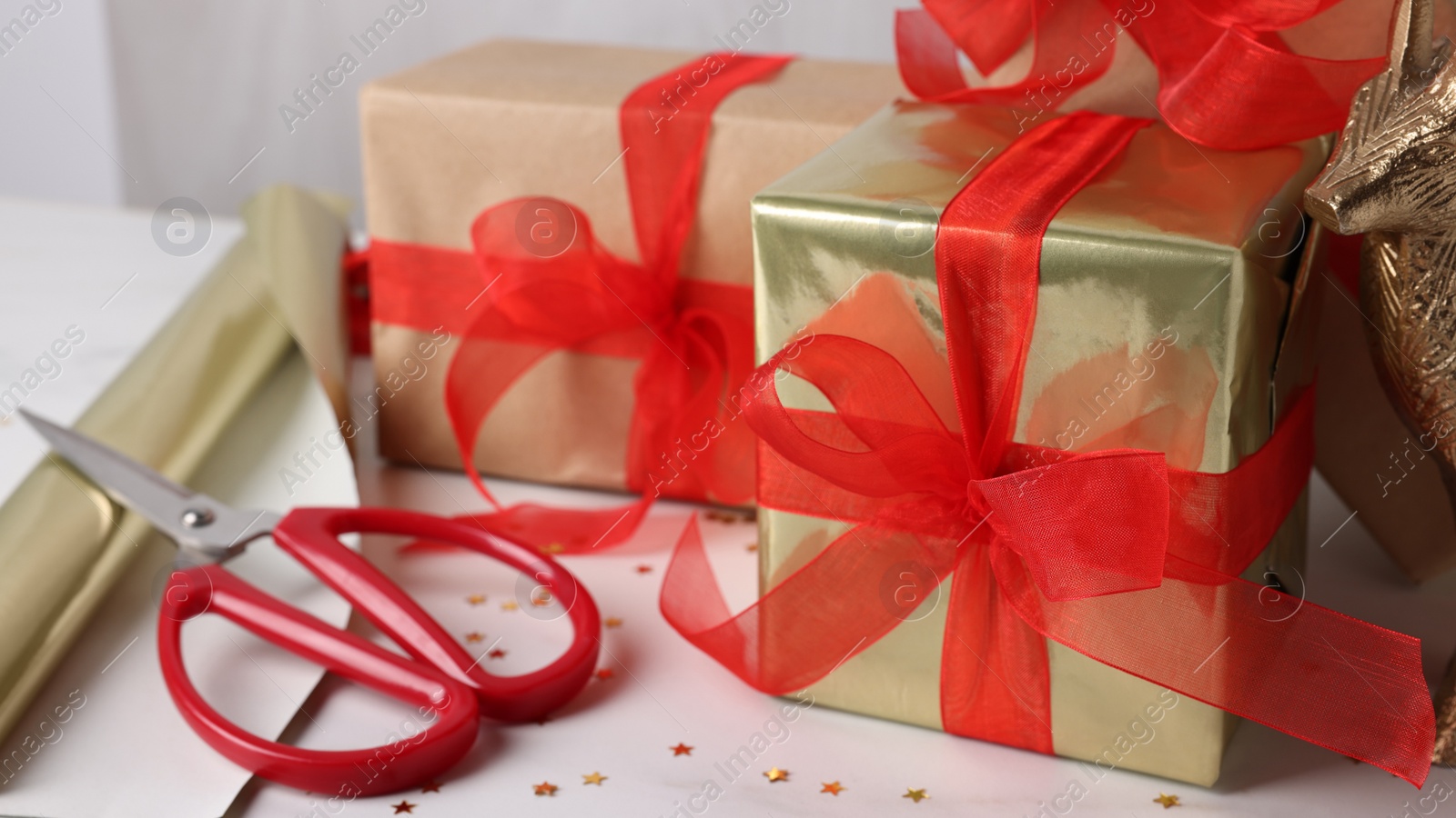 Photo of Beautifully wrapped gift boxes on white table, closeup