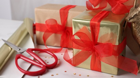 Photo of Beautifully wrapped gift boxes on white table, closeup