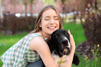 Photo of Young woman hugging her English Springer Spaniel dog outdoors