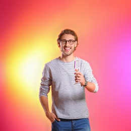 Photo of Portrait of happy man with champagne in glass on color background