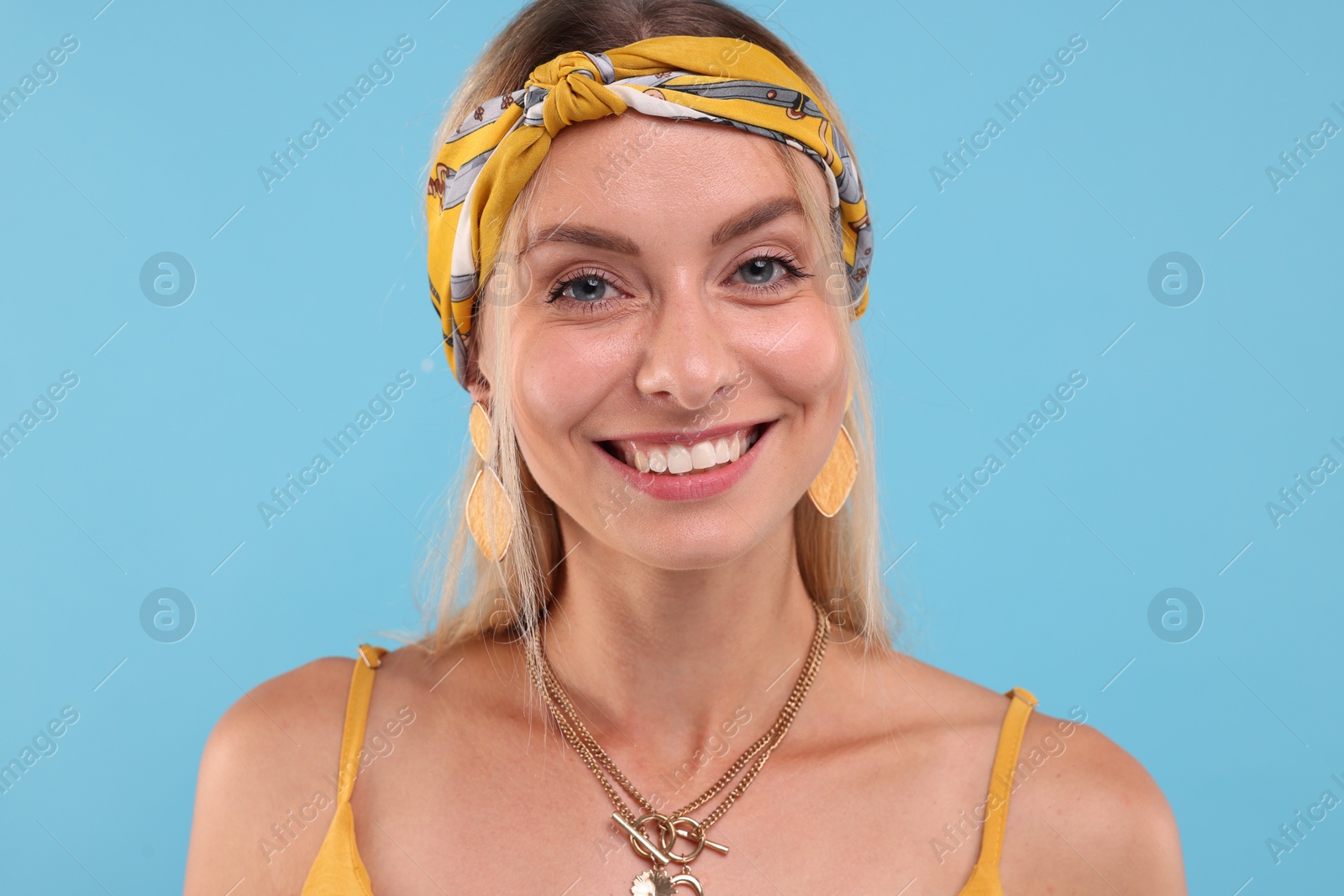 Photo of Portrait of happy hippie woman on light blue background