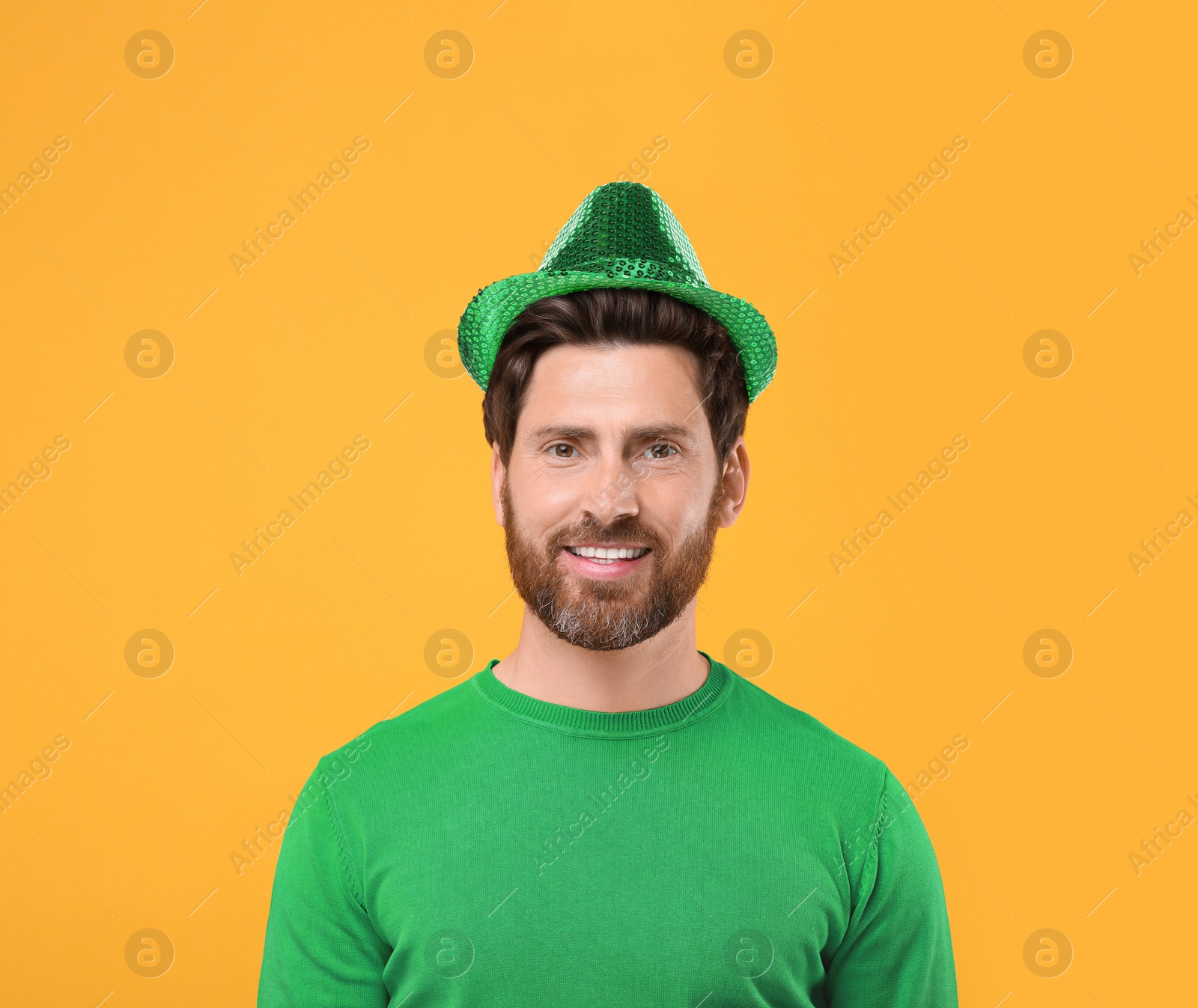 Image of St. Patrick's day party. Man in green leprechaun hat on golden background